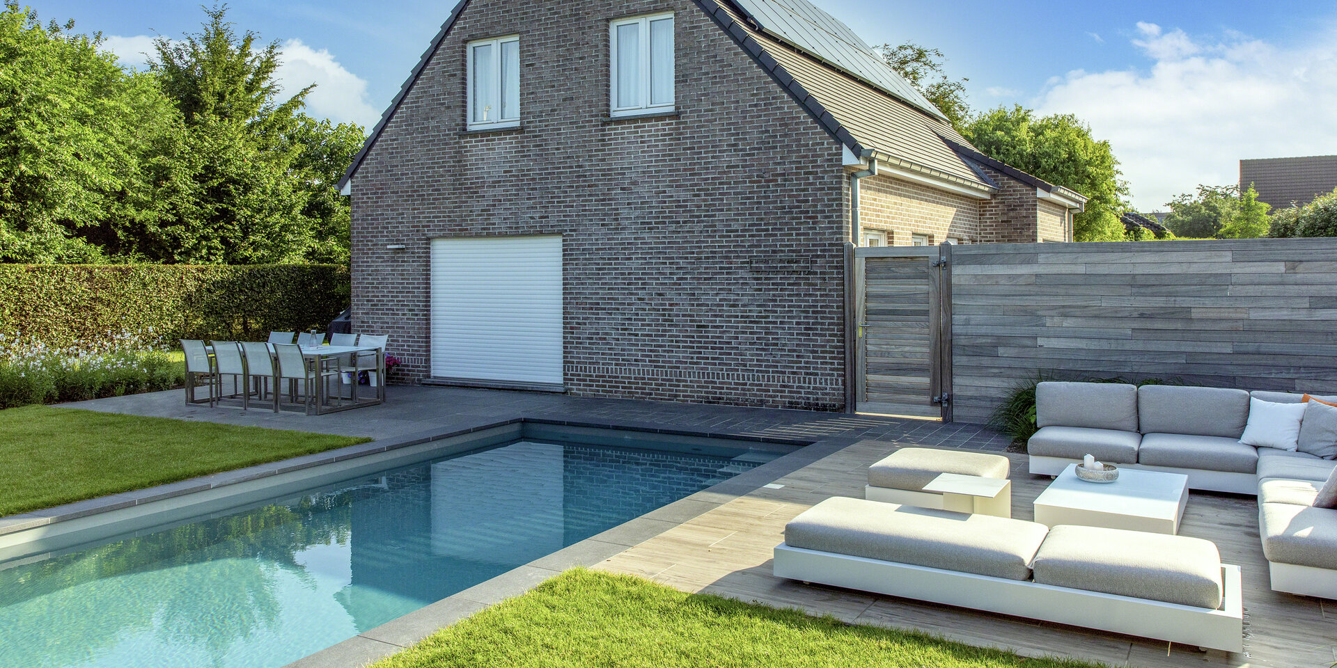 NIVEKO zwembad bij een Belgische woning met bakstenen gevel en moderne tuin
