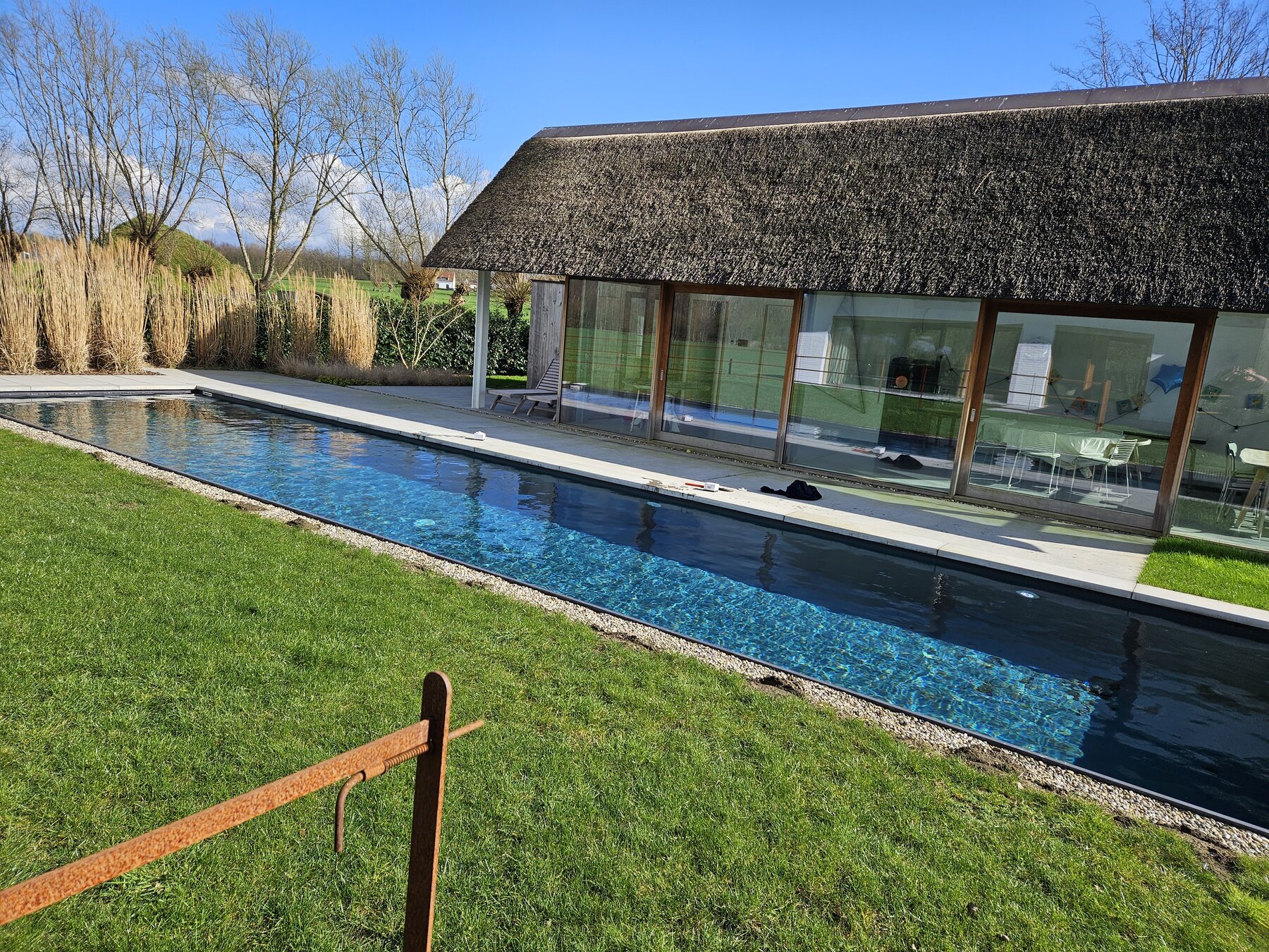 Betonnen zwembad met liner naast een woning, eigen project van Sublime Pools