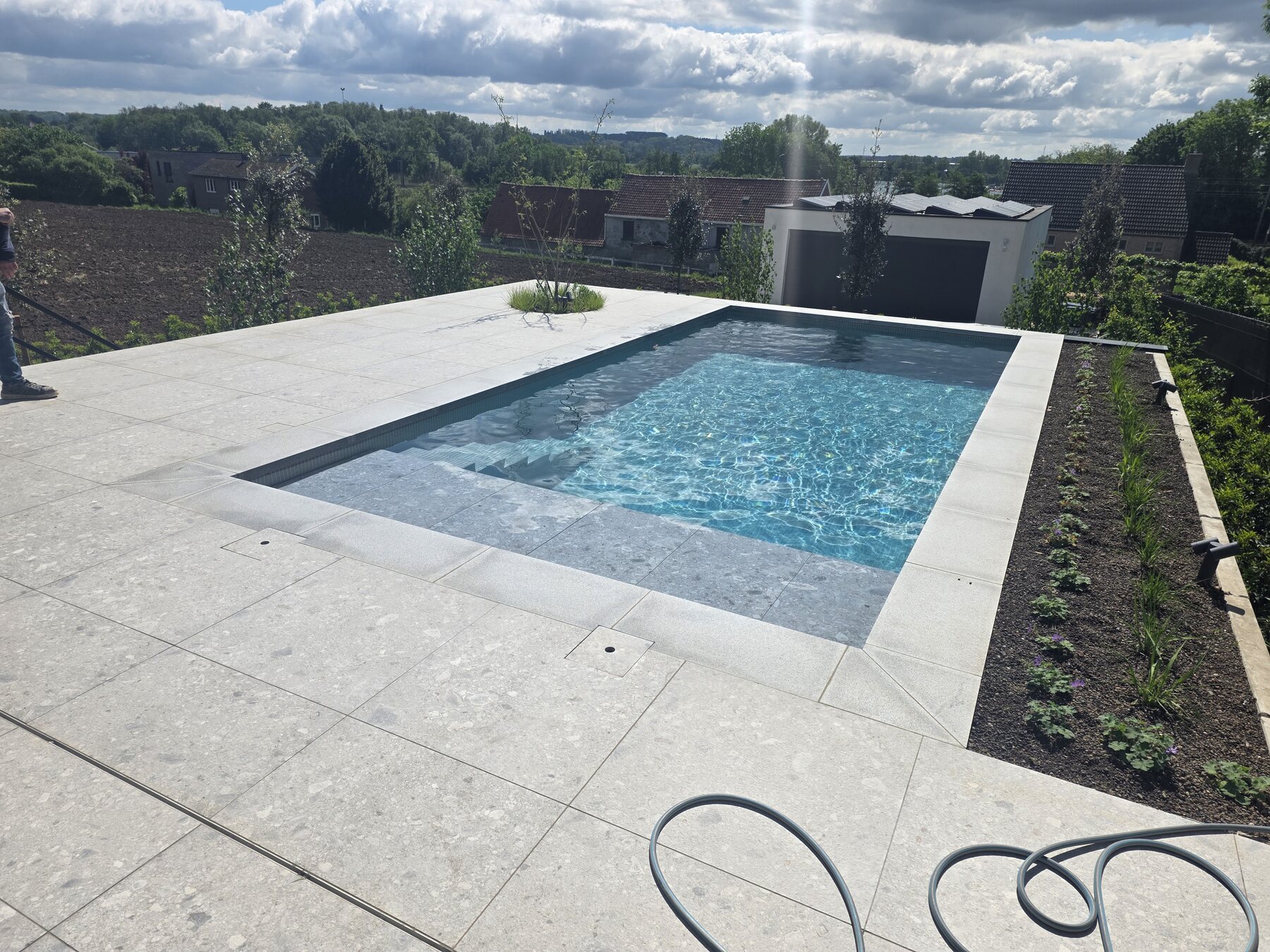 Zwembad met ruim terras en lichte boordstenen, eigen project van Sublime Pools